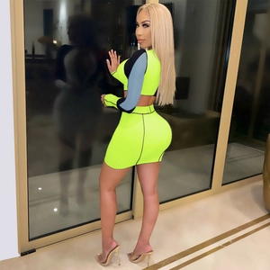 Detail of neon green ribbed knit two-piece set with blue contrast long sleeves and short skirt