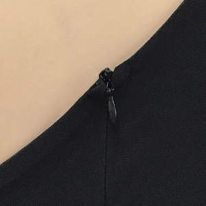 Macro detail of the invisible black zipper on mesh fabric jumpsuit with fine texture
