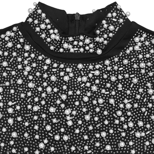 Détail de robe noire à col montant avec perles blanches et strass élégants décoratifs