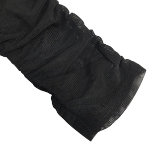 Detail shot of the ruched black mesh fabric texture and sheer sleeve craftsmanship