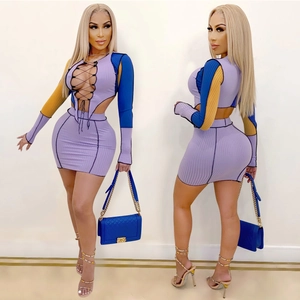 Detail of rib knit two-piece set featuring cutout lace-up top and bodycon skirt in purple