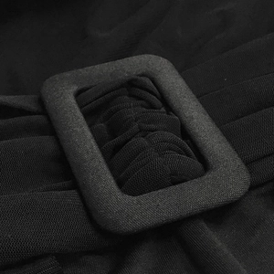Detail of waist adjustment buckle and mesh fabric on black one-shoulder jumpsuit