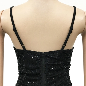 Detail of black sequined dress showing adjustable spaghetti straps and hidden back zipper