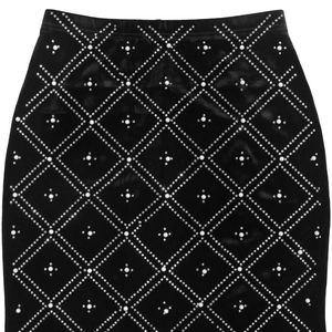Detail of black velvet skirt with diamond grid patterns and white pearl embellishments