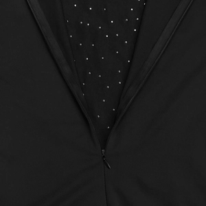 Vue macro de la fermeture éclair invisible sur robe noire ornée de strass argentés