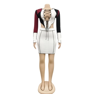 Detail of color-block knit crop top with cross lacing and white mini skirt structure