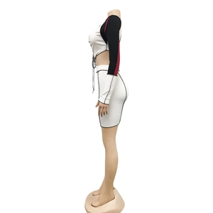 Detail of white knit set featuring contrast long sleeves and black contrast stitching seams