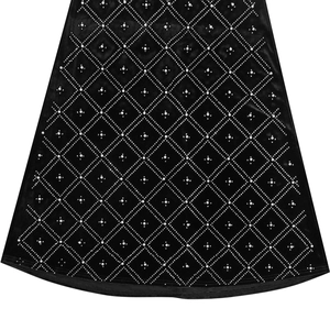 Detail of black velvet fabric with diamond patterns, silver rhinestones and white pearls