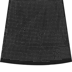 Détail du tissu élastique noir avec des strass argentés scintillants sur l'ourlet