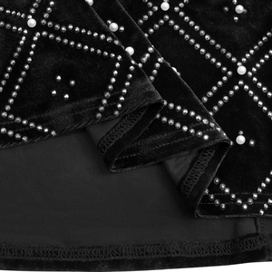 Detailed macro view of black velvet fabric with rhinestone trellis and pearl embellishments
