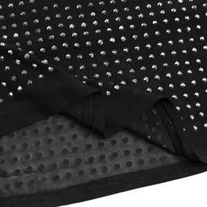 Détail du tissu en maille noire avec strass argentés brillants et coutures fines