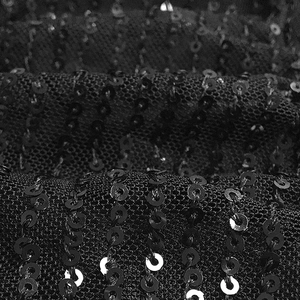 Macro shot of shimmering black sequins on fine mesh fabric for a sexy party dress