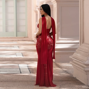 Detail of red sequined evening gown featuring open back and elegant shoulder streamers