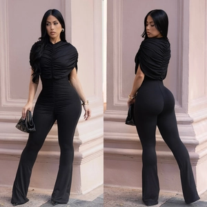 Detail view of black slim-fit jumpsuit featuring pleated neckline and flared pants
