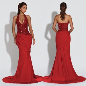 Detail of red sequin halter evening gown featuring backless design and fishtail skirt