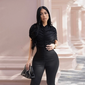 Detail showing the ruched chest design and slim fit fabric of the black jumpsuit