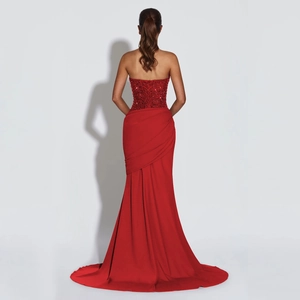 Detailed back view of red sequin halter evening gown featuring elegant lace-up closure