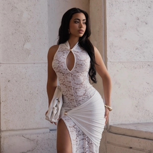 Close-up of white lace dress with teardrop cutout, metallic detail and ruched split hem