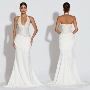 Detail of elegant white halter neck dress featuring sequins and side pleats design