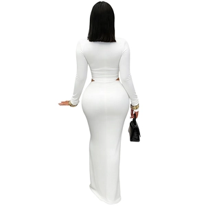 Rear view of women's white two-piece set featuring long sleeve crop top and high waist maxi skirt