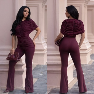 Front and back view of burgundy ruched jumpsuit with flared legs and cape sleeves