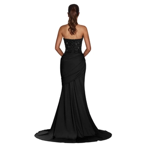 Detail of elegant black backless dress with sequins, crisscross straps, and fishtail skirt