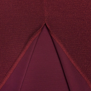 Macro shot of wine red glitter fabric with metallic sheen and back slit detail