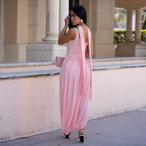 Detail of pink slim-fit maxi dress with long streamers and flowing draped fabric