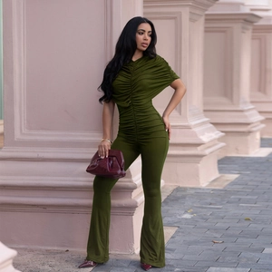 Detail of dark green slim fit jumpsuit featuring pleated texture and flared trousers