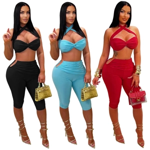 Three women modeling sexy halter neck crop tops and cutout pants in black, blue, and red
