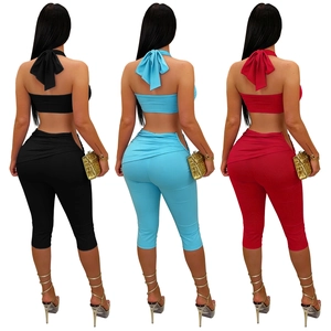 Detail view of lace-up crop tops and high-waisted leggings in black, blue, and burgundy