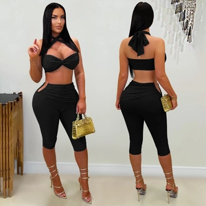 Detail of black two-piece set featuring halter neck top and side cut-out slim pants