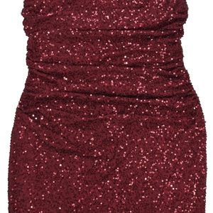 Détail du tissu à paillettes rouge foncé avec fronces horizontales sur robe de soirée