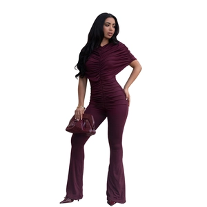 Detailed view of the elegant ruched bodice and asymmetric shoulder on this burgundy jumpsuit