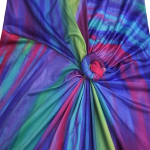Dettaglio del tessuto in maglia tie-dye vivace con un nodo centrale e pieghe a raggiera