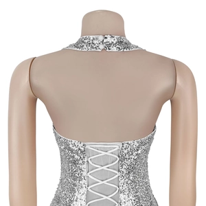 Detail of silver sequin dress showing halter backless design with white criss-cross straps