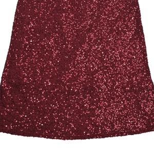 Détail rapproché du tissu à paillettes bordeaux pour une robe de soirée sexy moulante