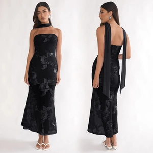 Détail de robe de soirée bustier noire avec broderie florale 3D et décoration de paillettes