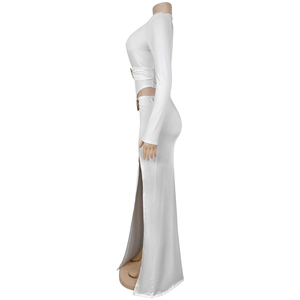 Detail of white long-sleeved crop top and high slit skirt with gold ring ornaments