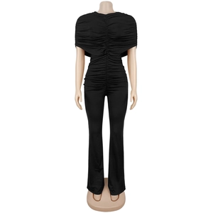 Detailed view of elegant black slim fit jumpsuit with shawl-style pleated top and flared pants