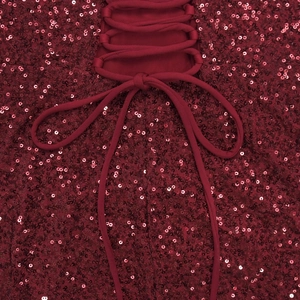 Détail d'une robe à paillettes bordeaux montrant le laçage au dos et la texture du tissu