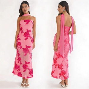 Détail d'une robe longue rose bustier avec broderies florales rouges et foulard assorti