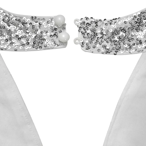 Detail of white halter neck dress featuring silver sequins and pearl button closure