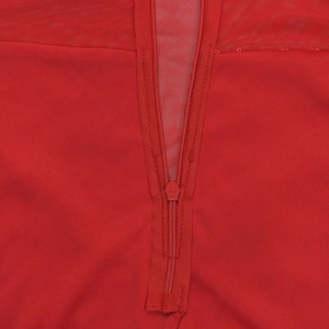 Detailed macro view of the YCC zipper closure and mesh stitching on the red dress