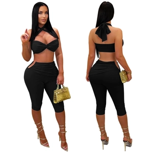 Detail view of black two-piece set featuring cutout waist leggings and halter top