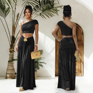 Détail du top noir asymétrique et jupe longue avec ornement floral doré élégant