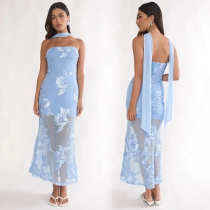 Détail d'une robe bustier bleu clair avec broderie florale et tissu en maille transparente