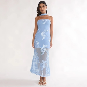 Détail d'une robe en tulle bleu clair brodée de fleurs avec accessoire foulard assorti