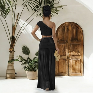 Détail d'un haut court à une épaule noir et d'un ensemble jupe longue plissée à la taille