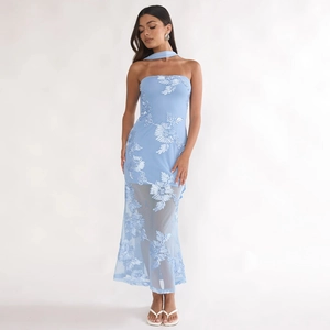 Détail d'une robe bustier bleu clair avec broderies florales blanches et écharpe assortie